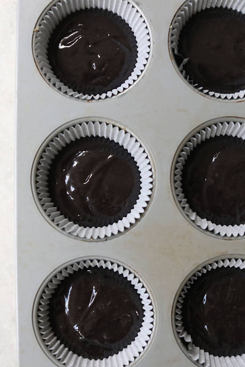 Black velvet cupcakes in cupcake tin before being baked in the oven.