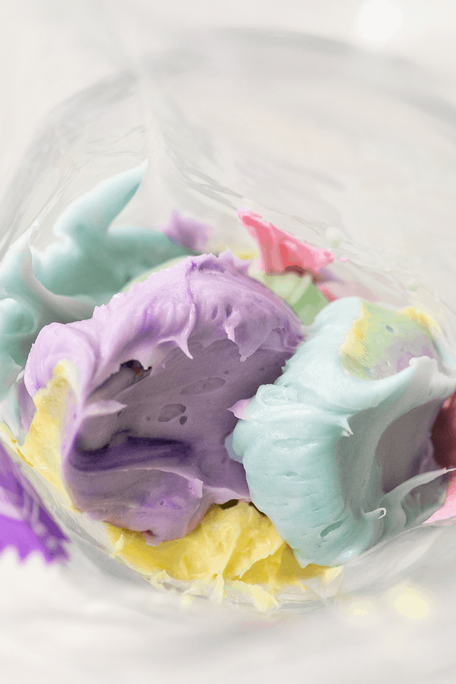 Colorful buttercream frosting in a piping bag.