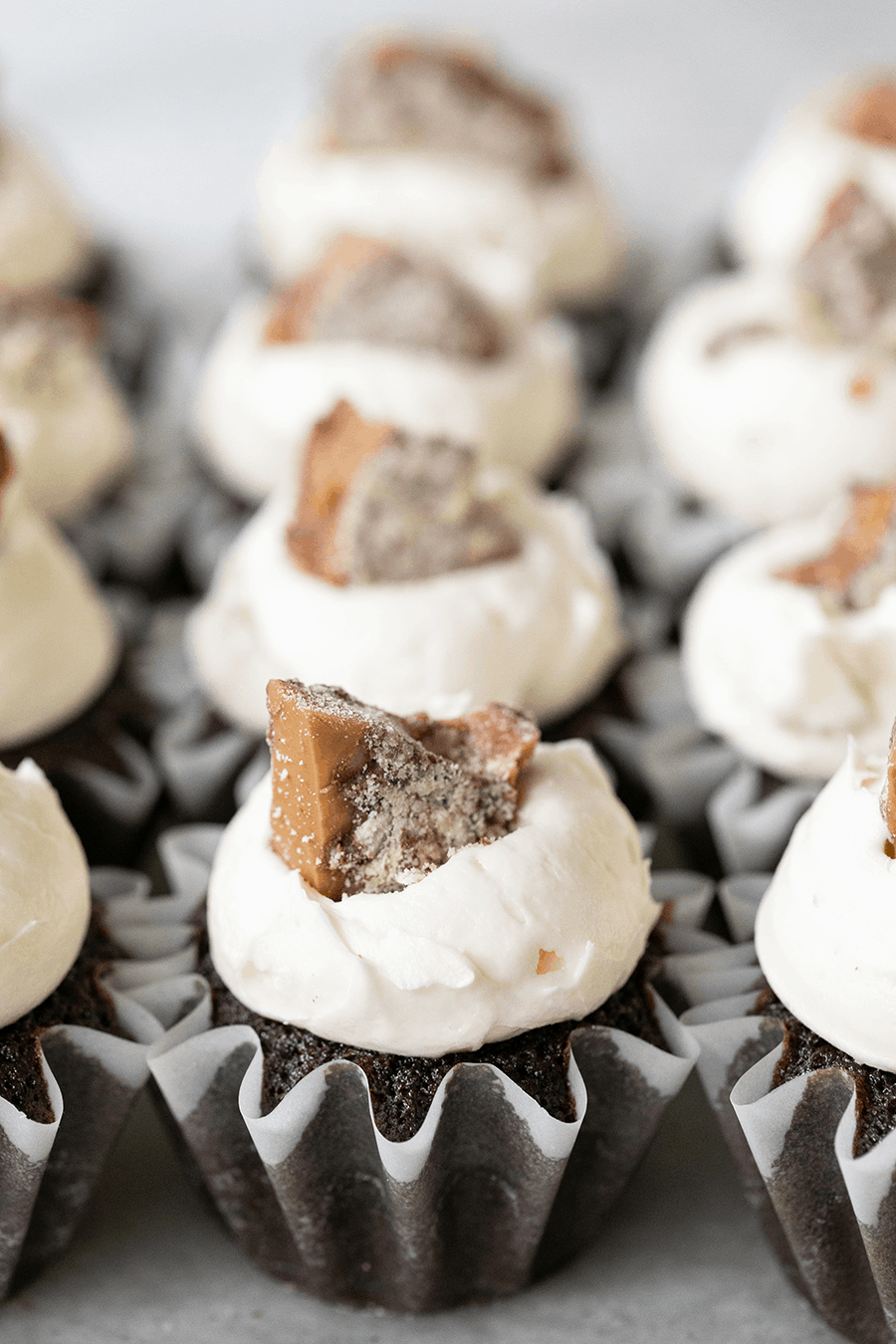 Chocolate cupcakes with homemade frosting topped with a chunk of toffee.