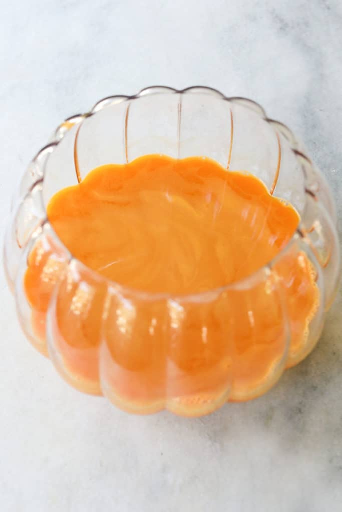 Orange punch in a glass pumpkin bowl.