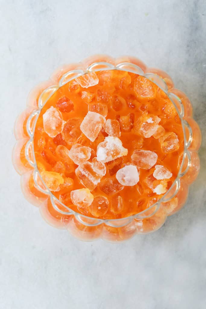 Adding ice to a Halloween punch for kids.