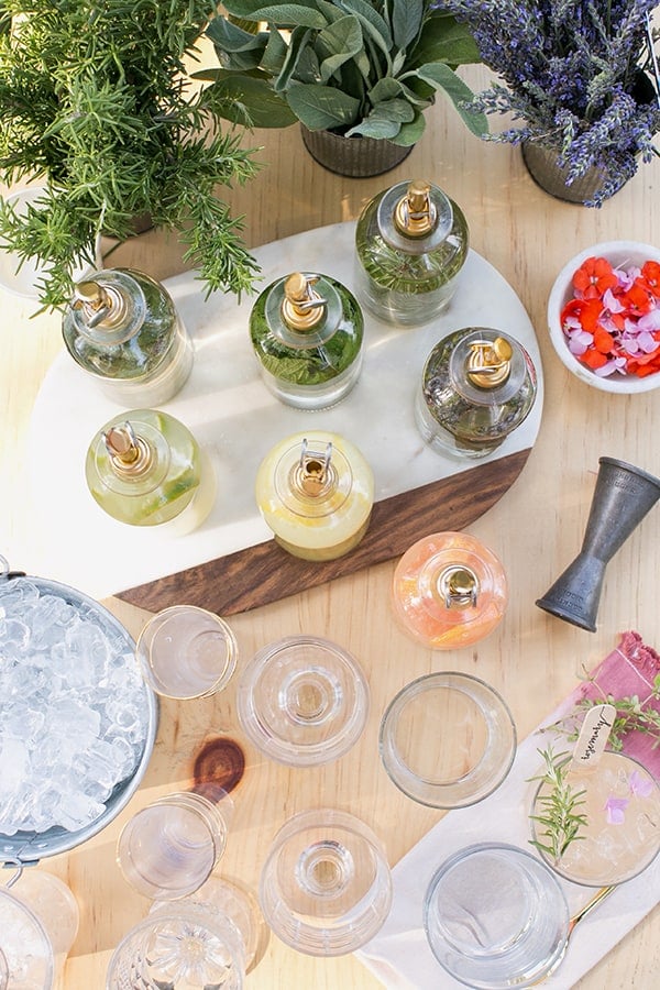 bottles of simple syrup on a bar with flowers.