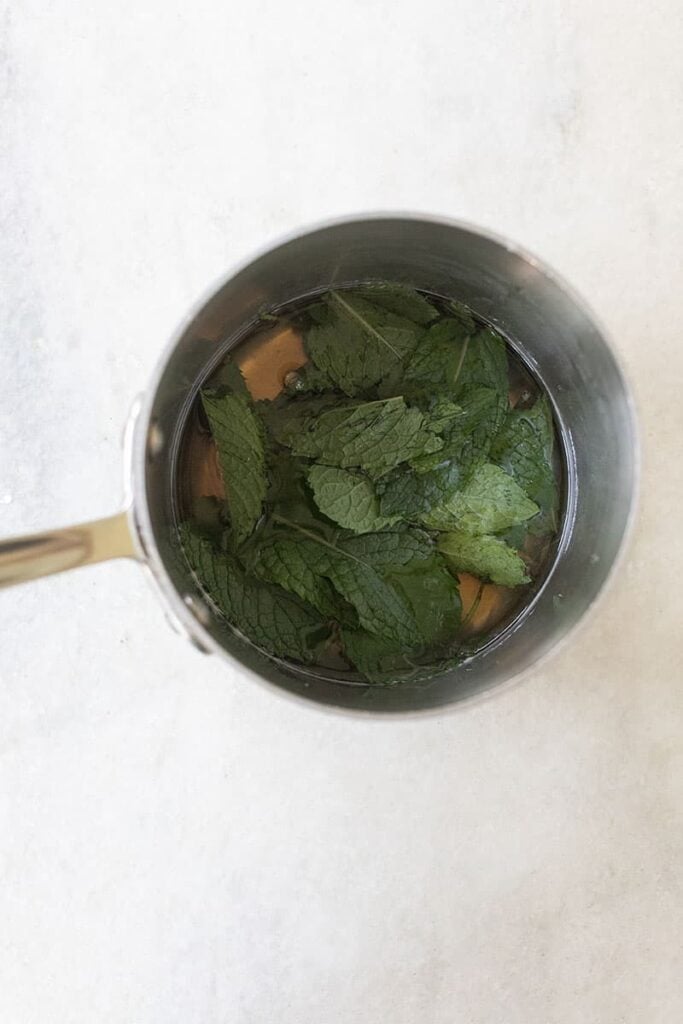 Infusing simple syrup with fresh mint leaves.