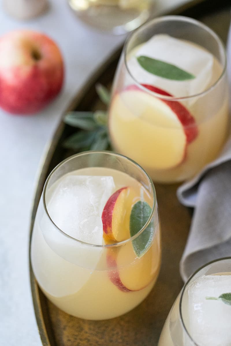 Apple and Ginger Sprizter on a gold tray to serve for a Thanksgiving cocktail.