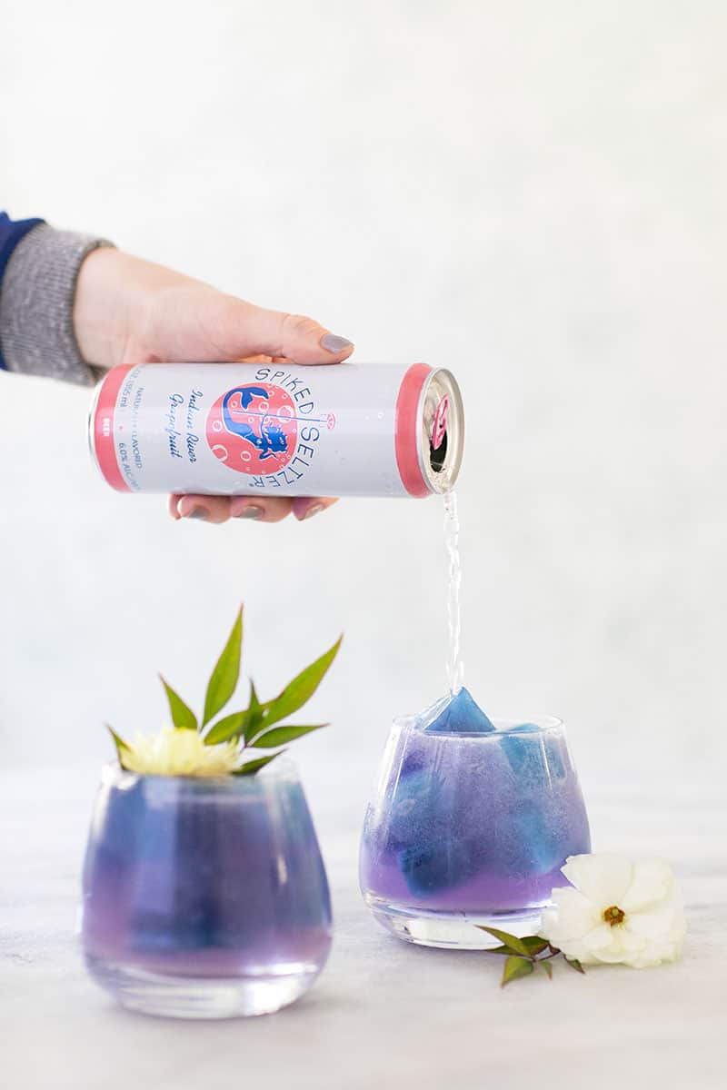 A purple Paloma cocktail made with spiked seltzer and butterfly pea flower.