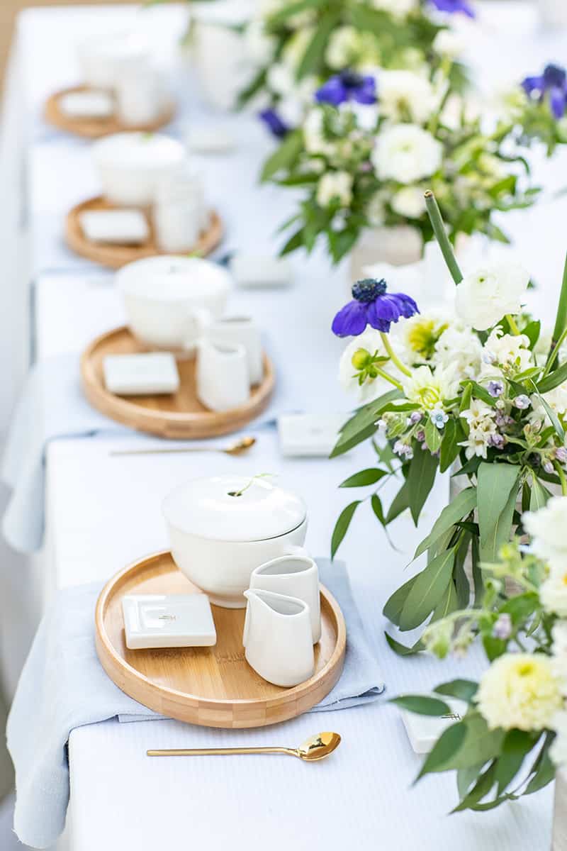 Tea party cups and flowers on a table for a bridal shower tea party.