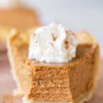 Slice of pumpkin pie with whipped cream on the top.