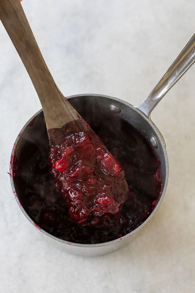 Easy cranberry sauce on a wooden spoon.