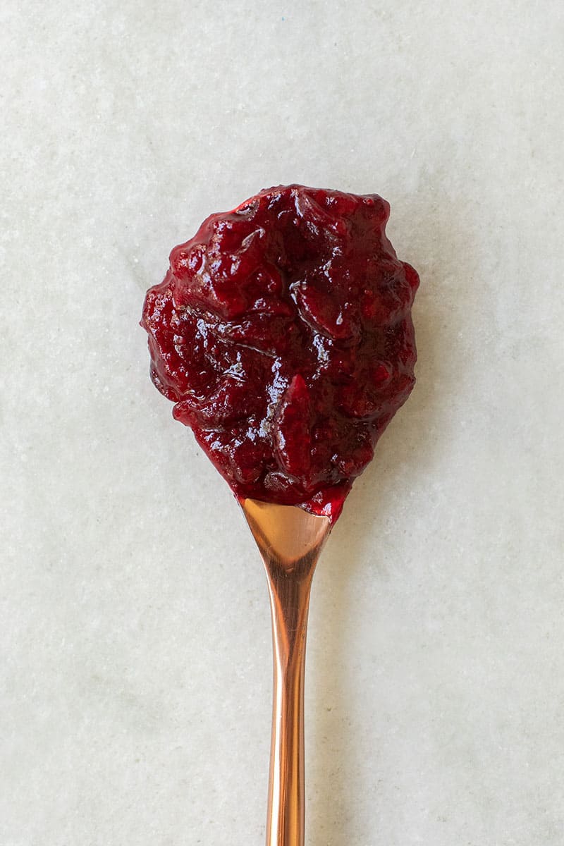 cranberry sauce recipe on a copper spoon.