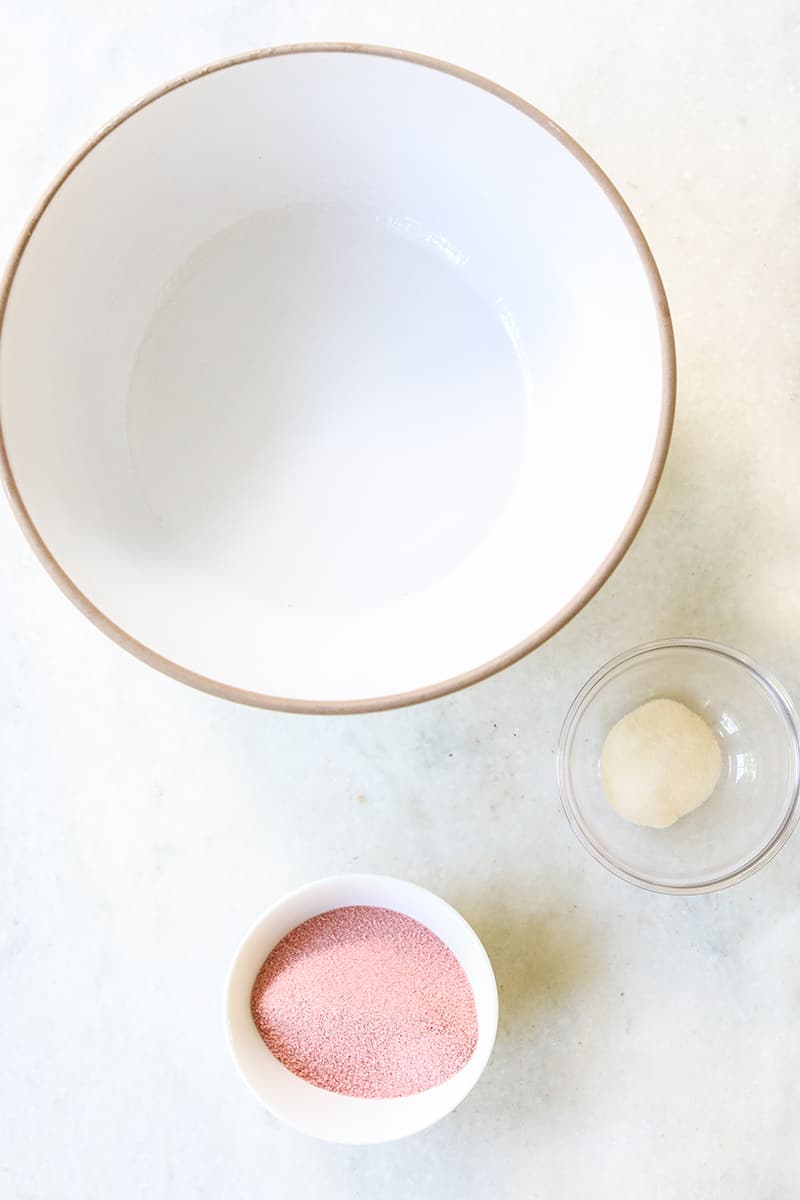 White bowl with vodka, gelatin and red jello to make jello shots.