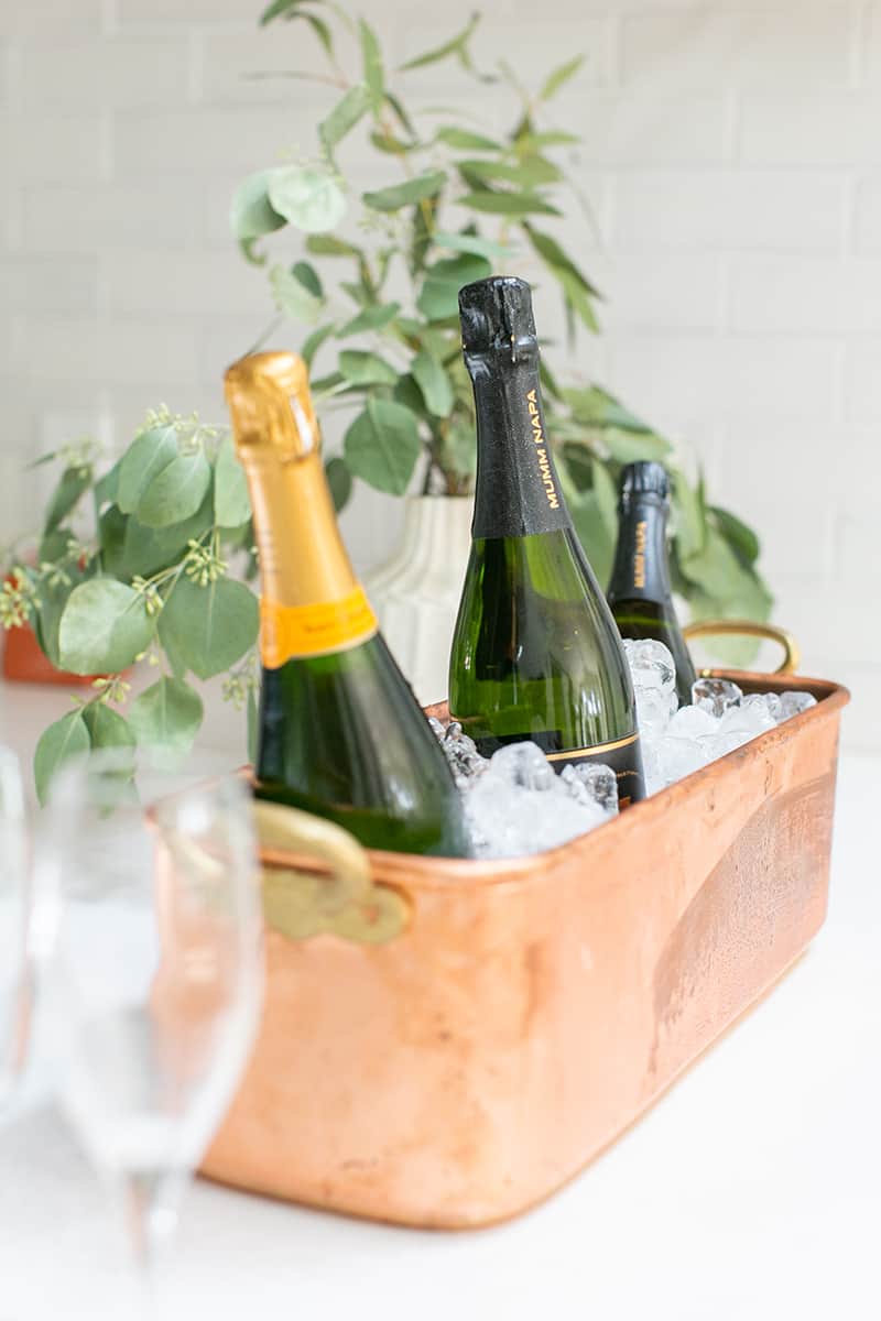 Bottles of Champagne in brass ice bucket from Williams Sonoma. 