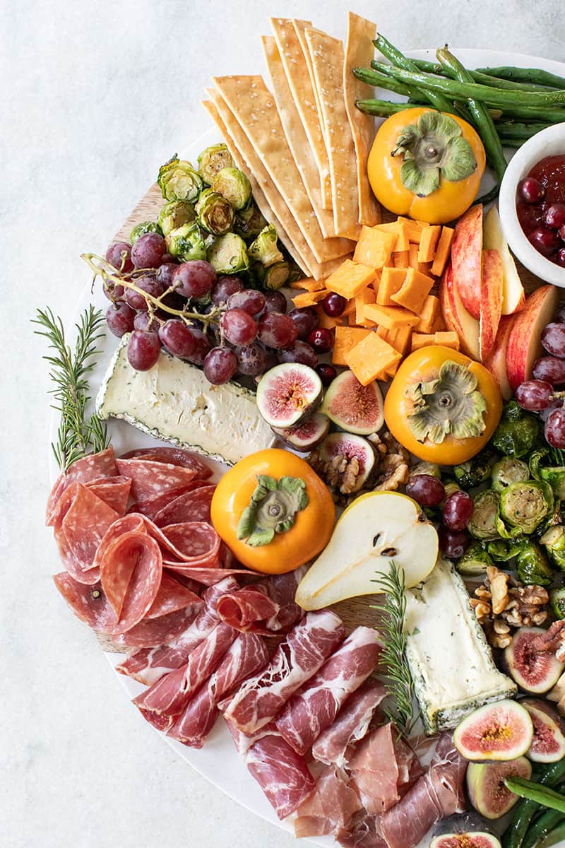 Easy Thanksgiving appetizers with meat, fruit, crackers, cheese and grapes. 