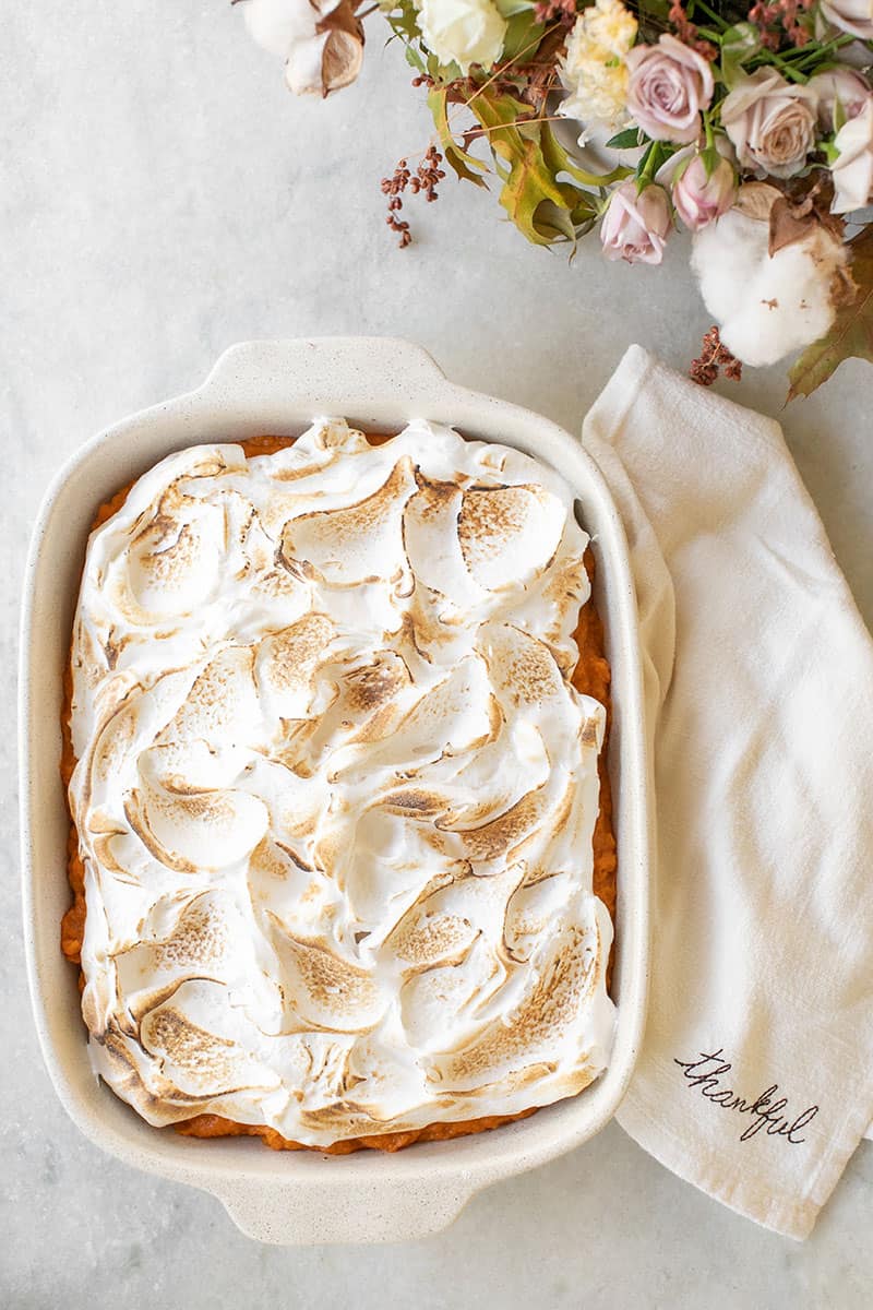 Overhead of sweet potato casserole with marshmallow fluff and a napkin that reads Thankful.