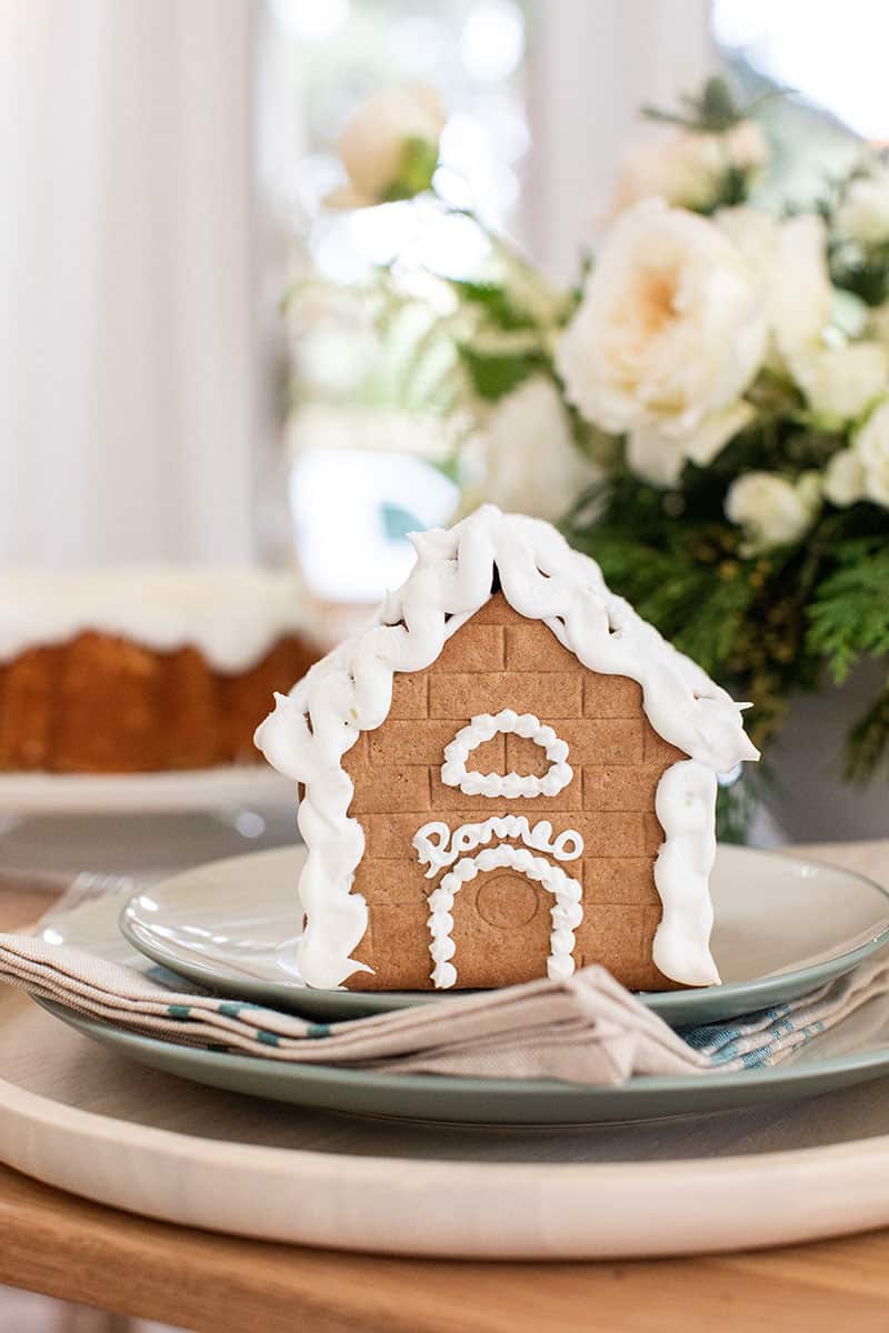 Gingerbread house on a Christmas Table Setting with Romeo written on it in frosting. - christmas morning