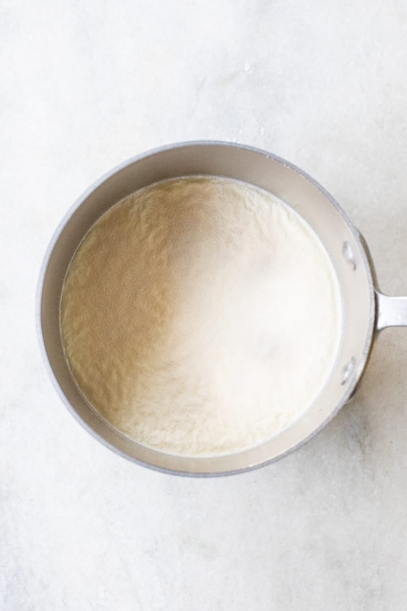 Pan with cream and eggnog and gelatin setting to make eggnog panna cotta 