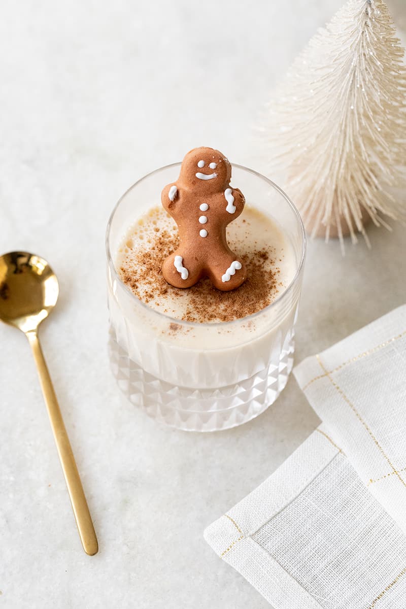 Glass of eggnog panna cotta with a gingerbread man.