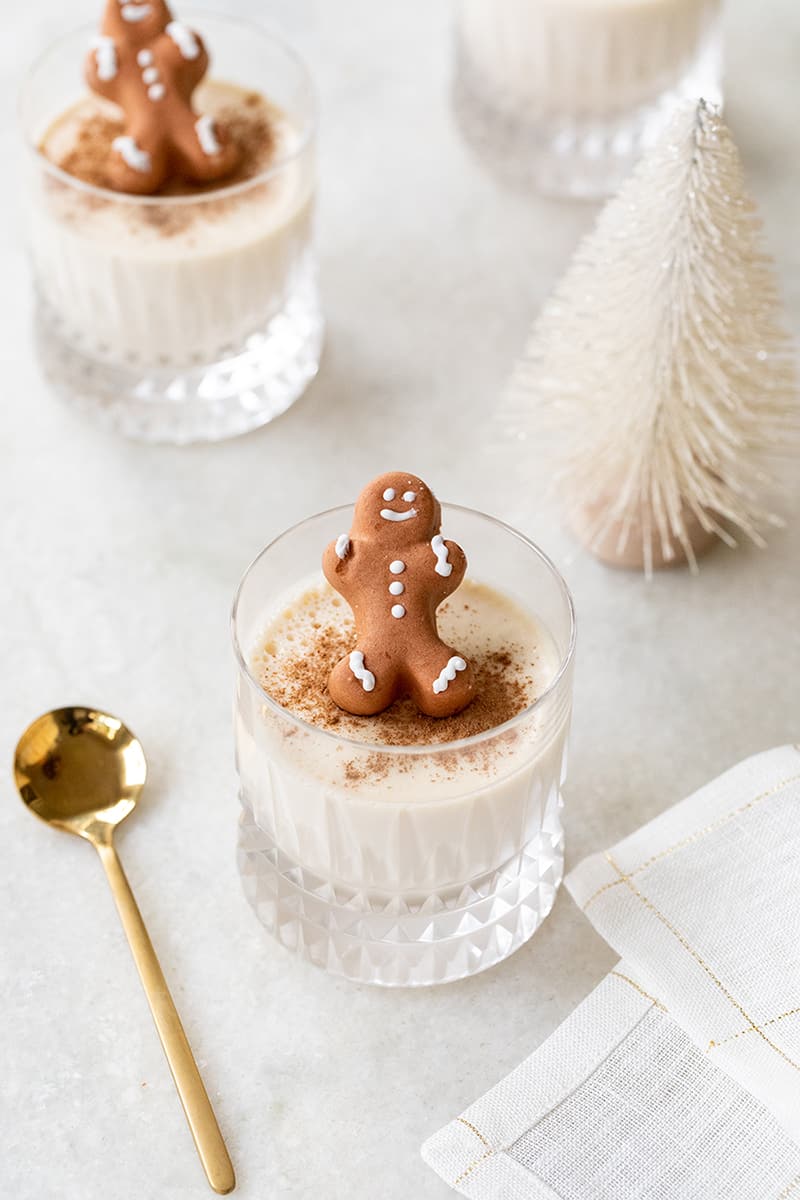 Eggnog Panna Cotta with cinnamon sprinkled on the top and a little gingerbread man garnished.