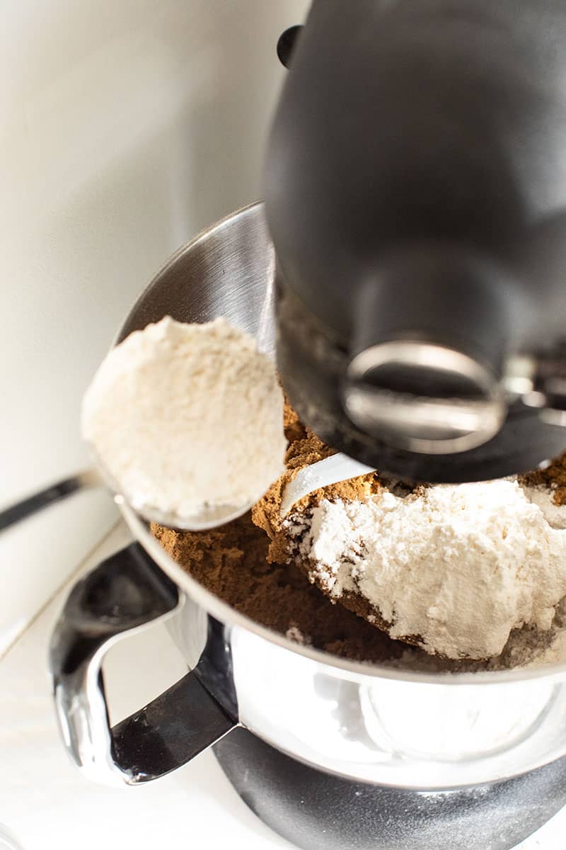 Adding flour to dough in an electric mixer.