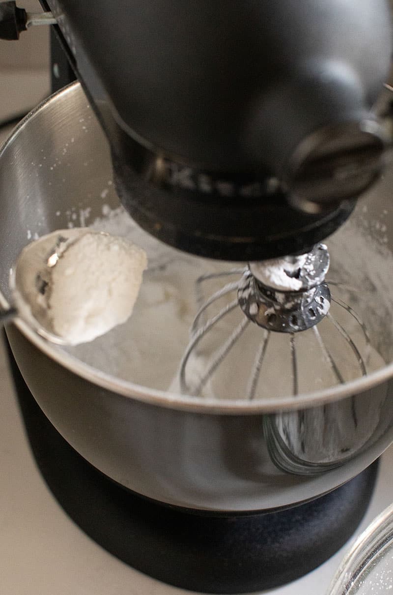 Spooning in powdered sugar to make gingerbread house frosting.