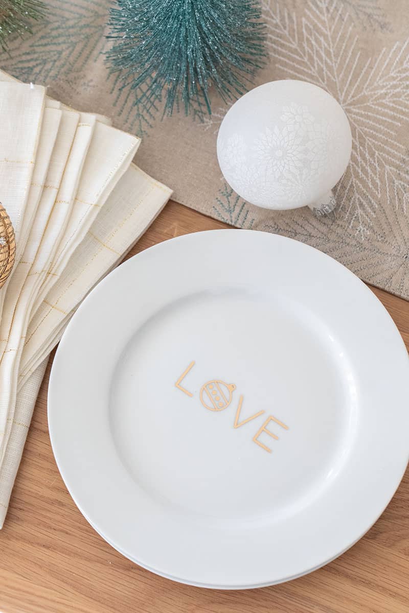 Gold and white plate with ornaments and bottle brush Christmas tree.