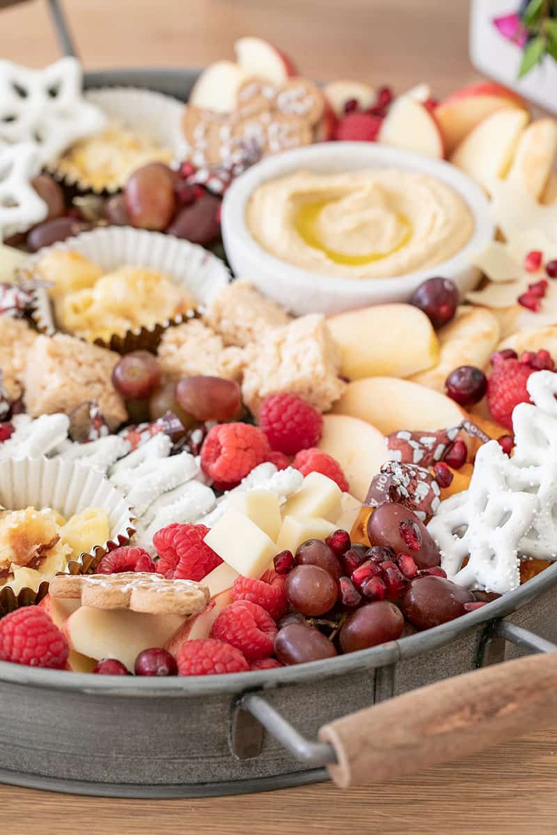 Christmas Appetizer Platter for kids in a round galvanized tray with grapes, berries and cheese. 