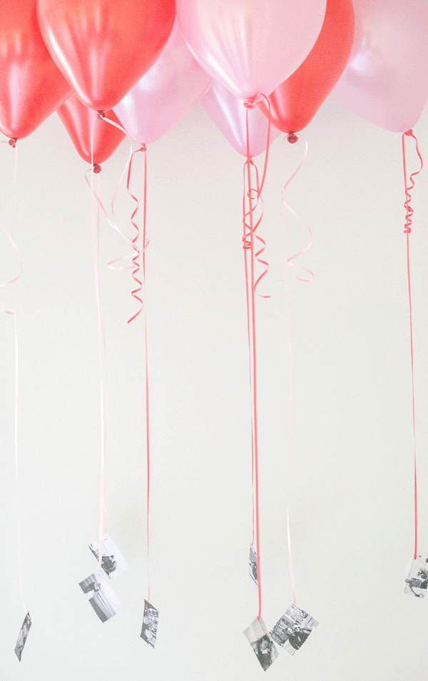 Pink and red balloons with black and white photos attached to the bottom.