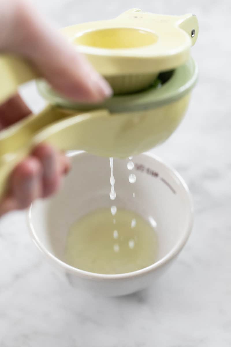 Squeezing limes in a small bowl.