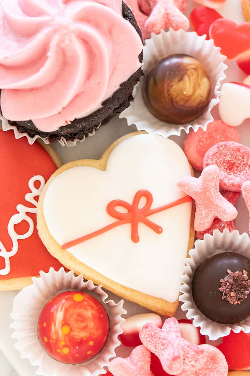 Heart shaped sugar cookies and pretty truffles on a Valentine's Day dessert platter.