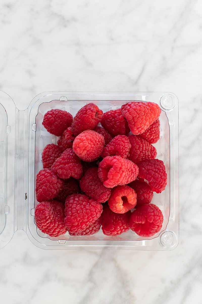 Container of fresh raspberries for dessert platter.