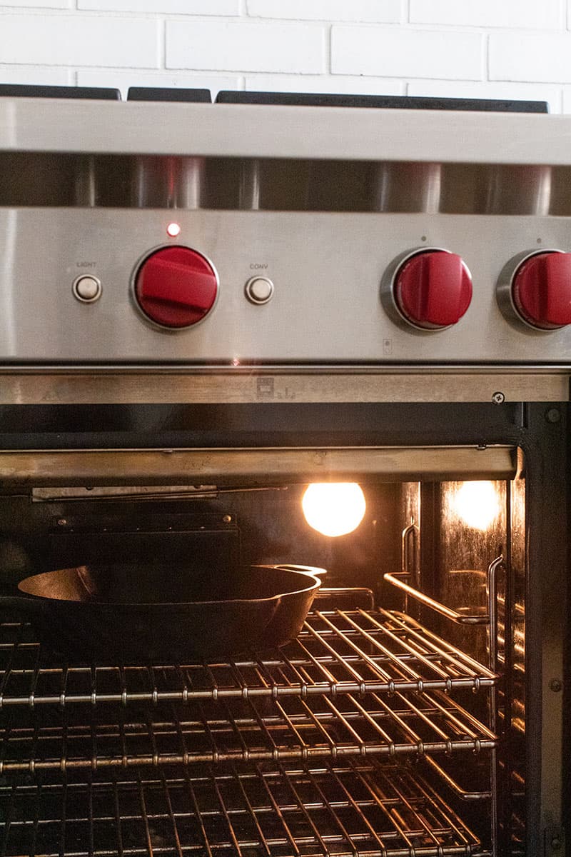 cast iron skillet preheating in an oven 