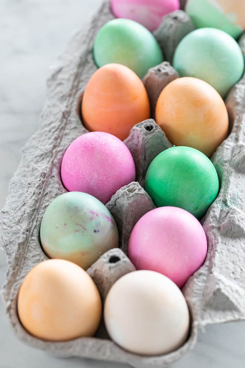 Colored easter eggs in an an egg carton 