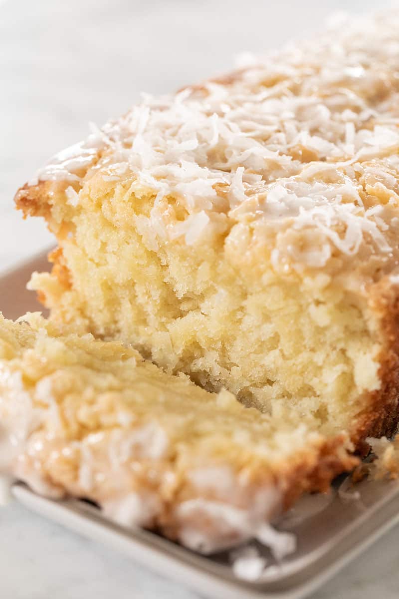 coconut loaf cake with a slice taken off.