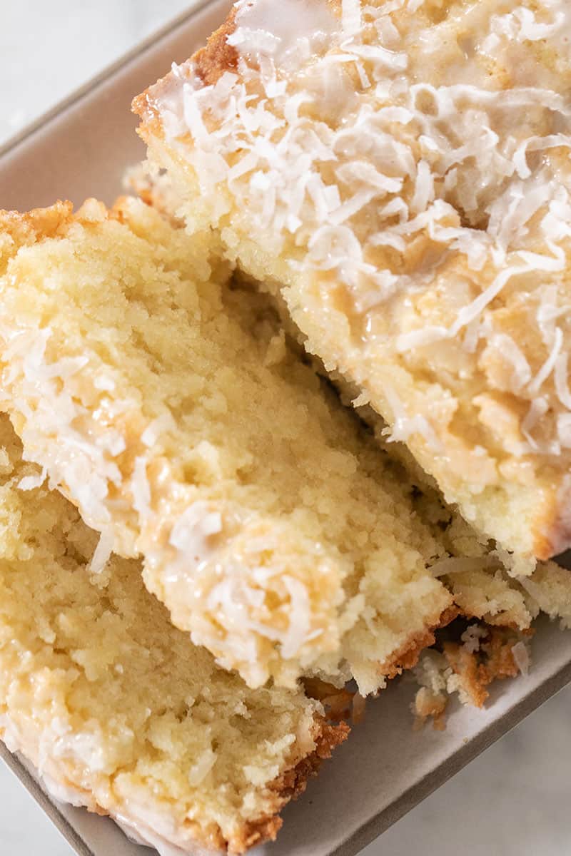 Slices of loaf cake with coconut on top.