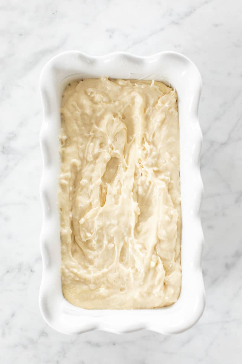 Batter in a white ceramic loaf pan.