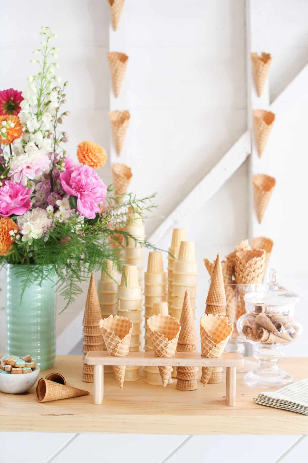 Waffle cones and flowers on an ice cream sundae bar.