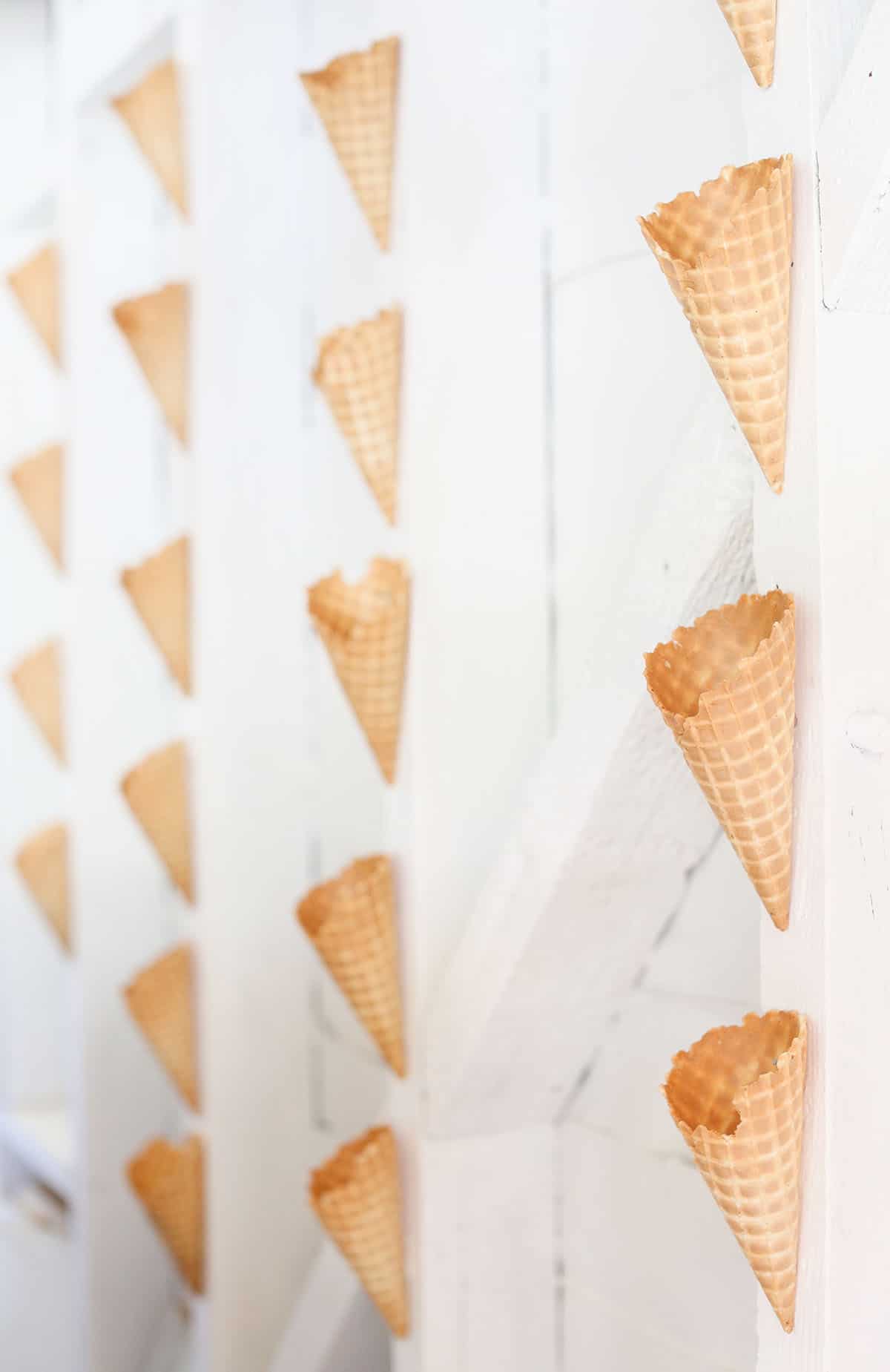 Waffle cones on a wall behind an ice cream bar.