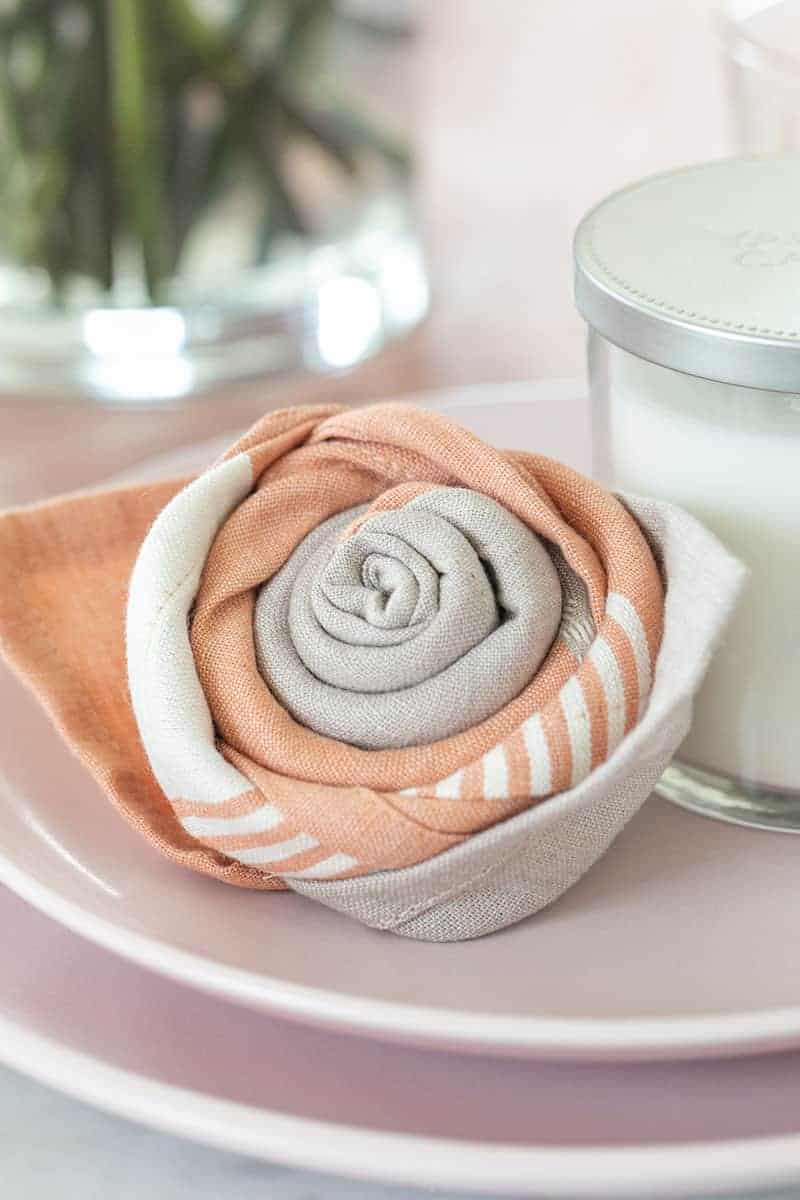 Mother's day napkin fold, a pink rose on a plate.