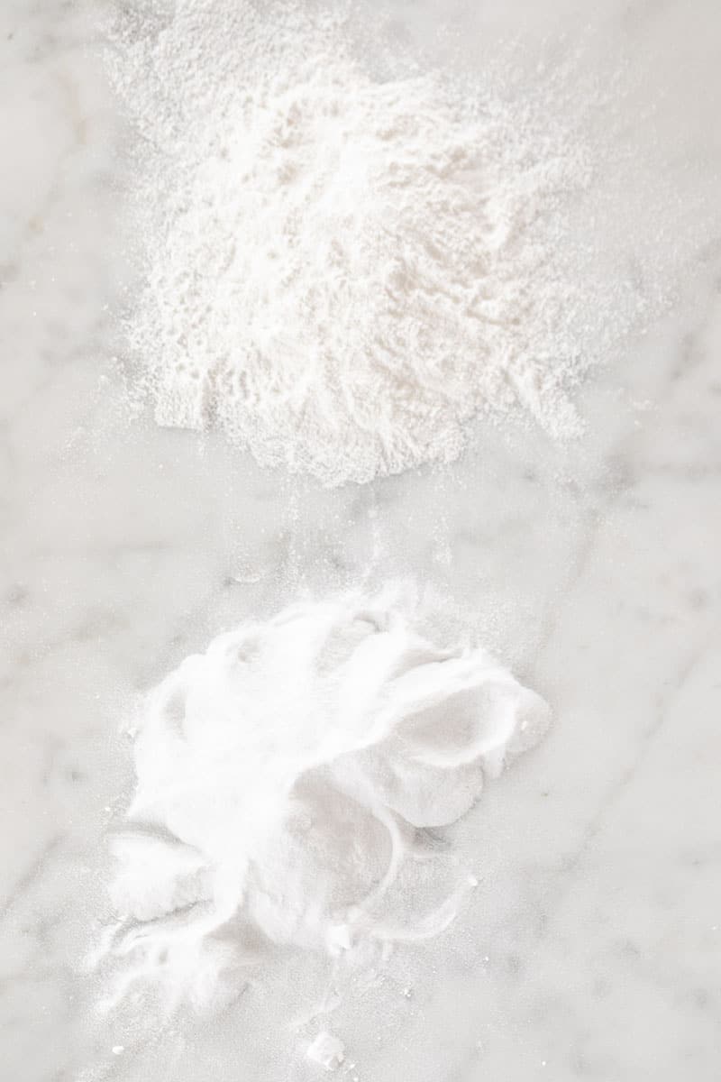 Baking soda and baking powder on a marble table.