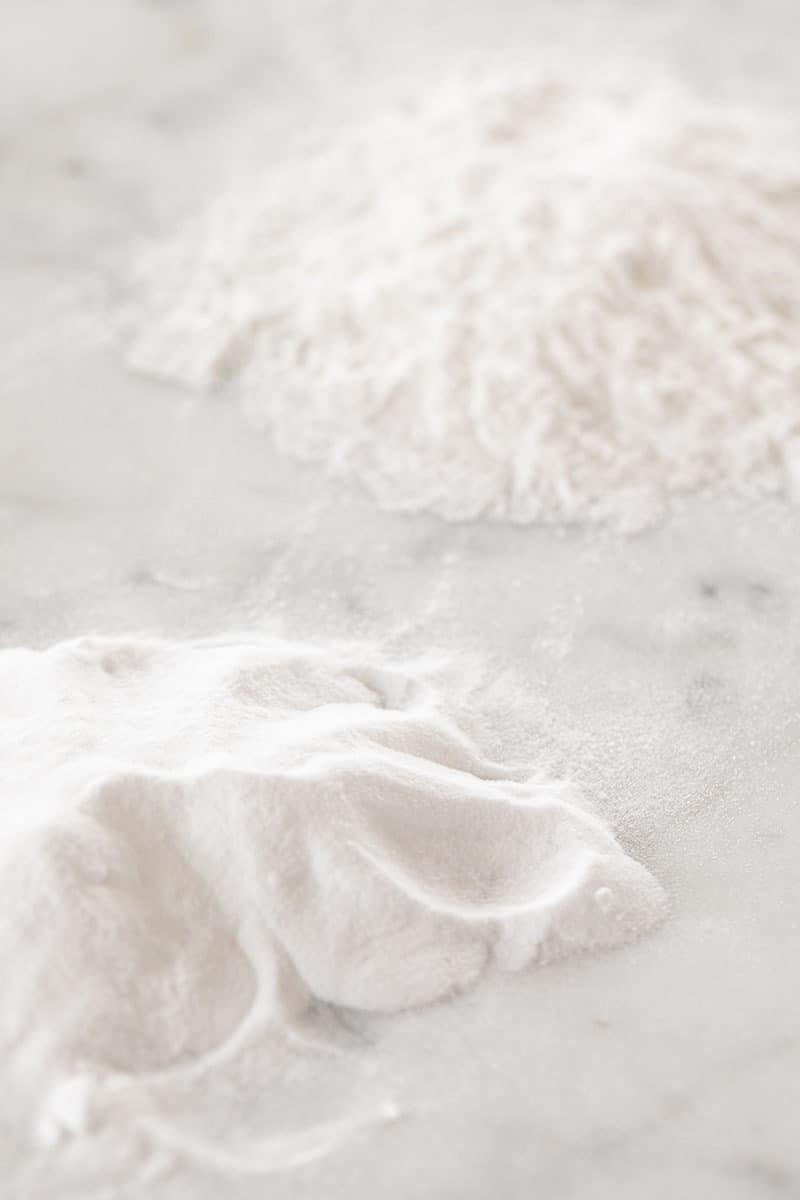 pile of baking soda and baking powder on a marble table.