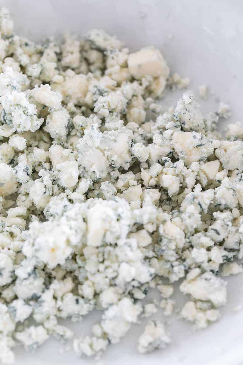 Blue cheese crumbled in a bowl.