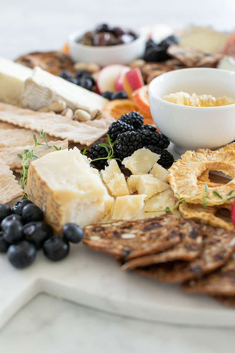 cheese and meat platter with berries, cheese and crackers.