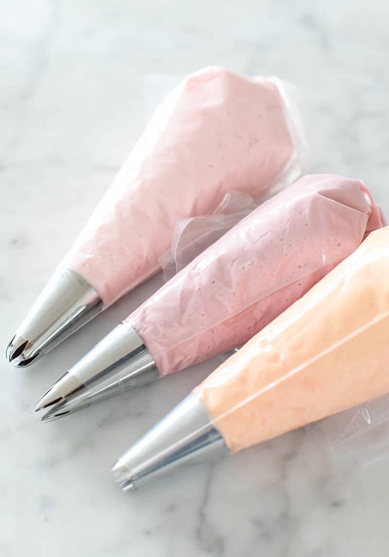 Colored frosting in piping bags with fitted tips.