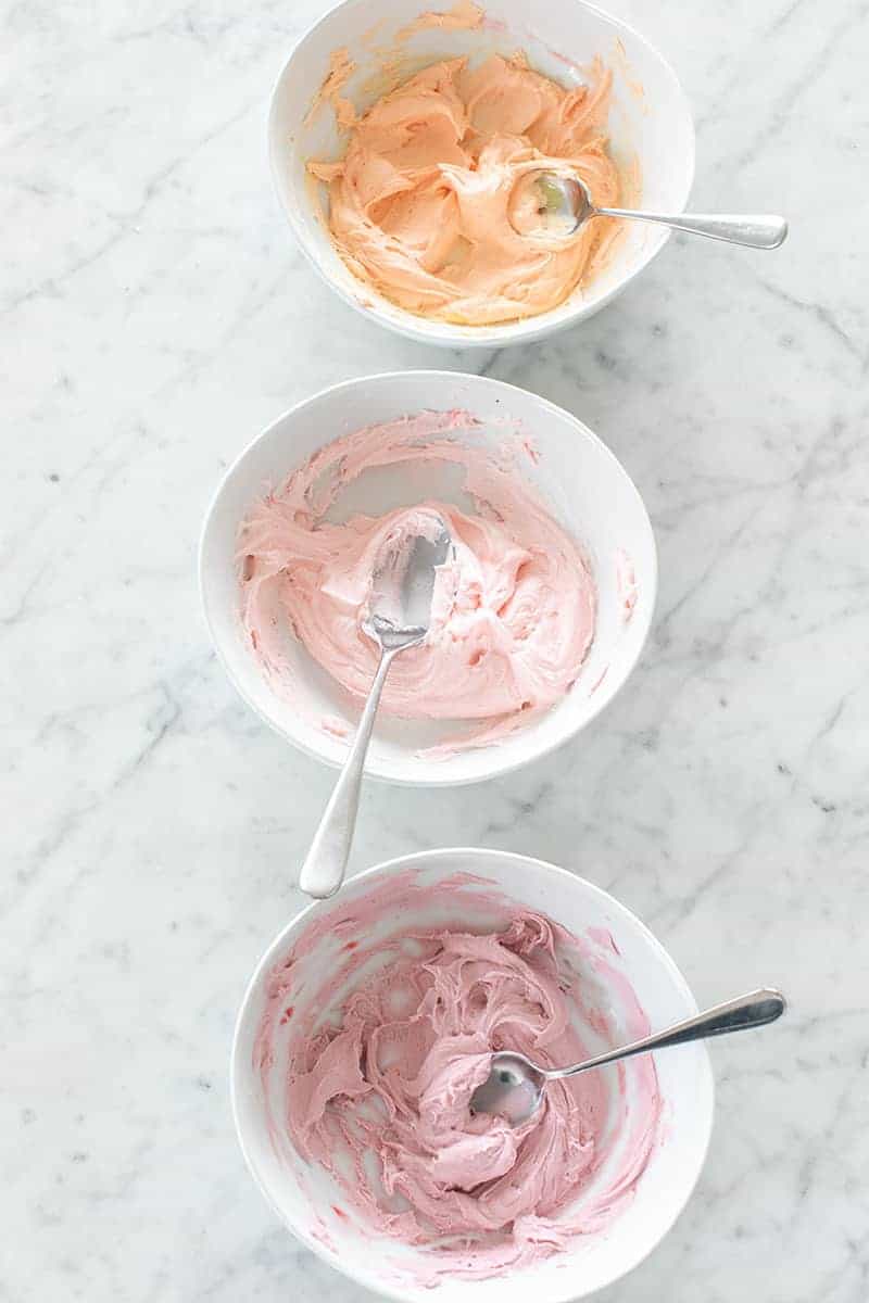 Three bowls of colored frosting 