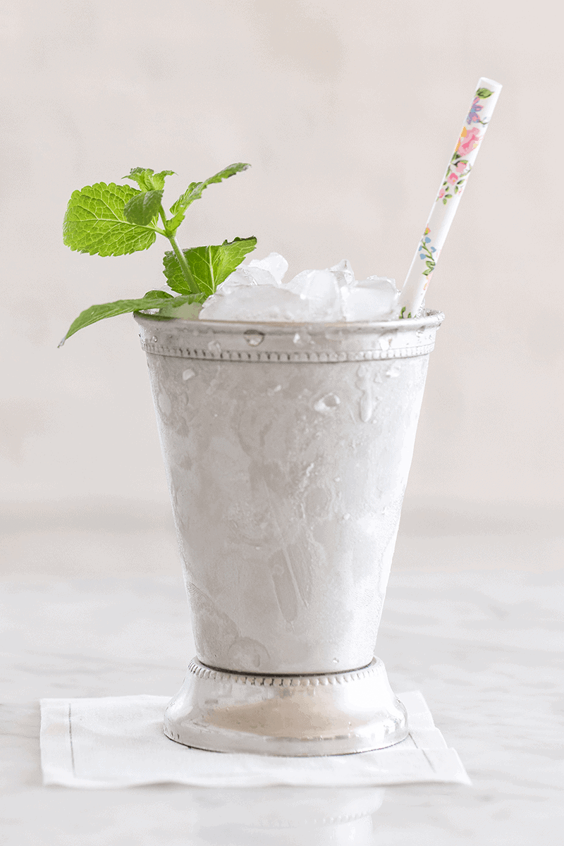 A classic mint julep with floral straw and mint.