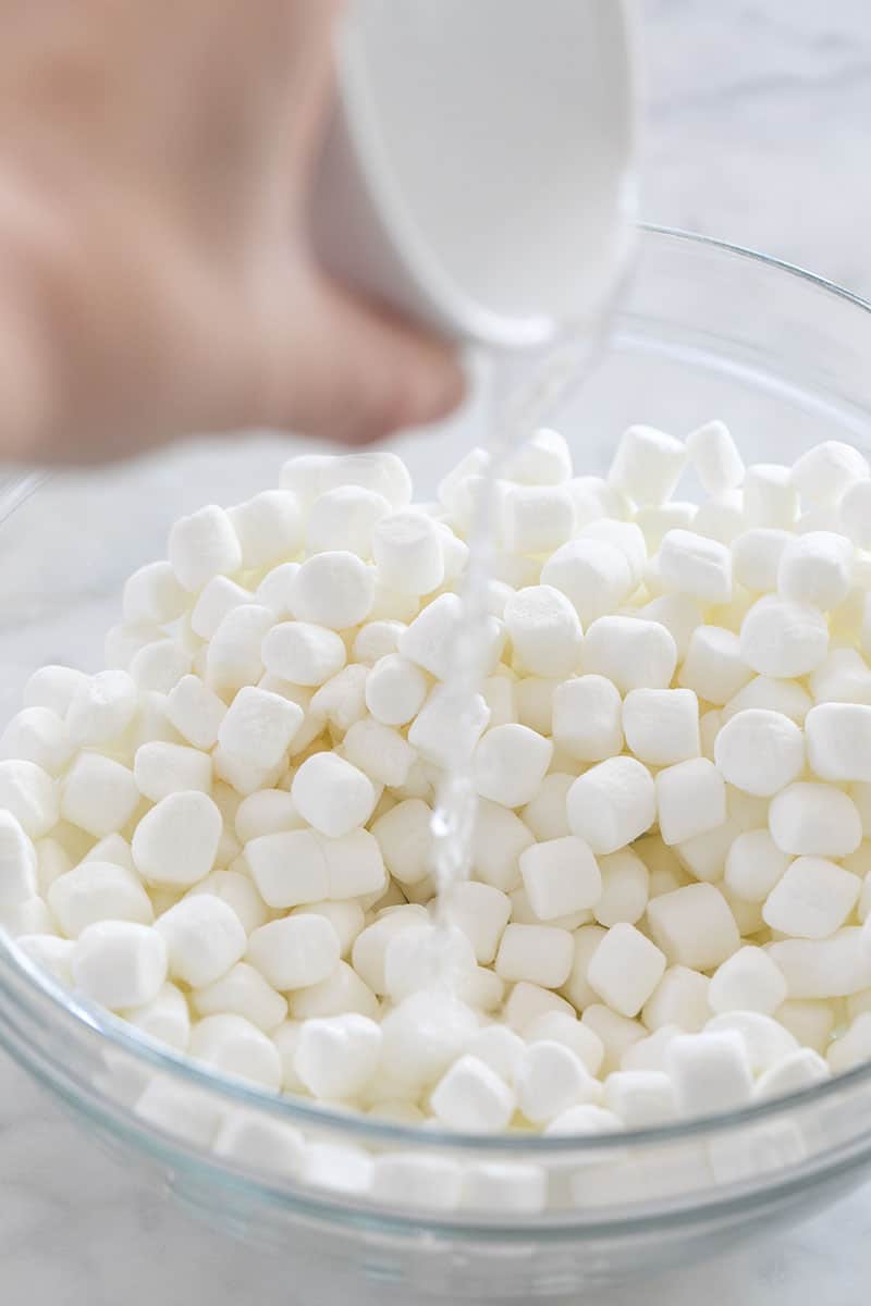 Pouring water into a bowl of marshmallows.