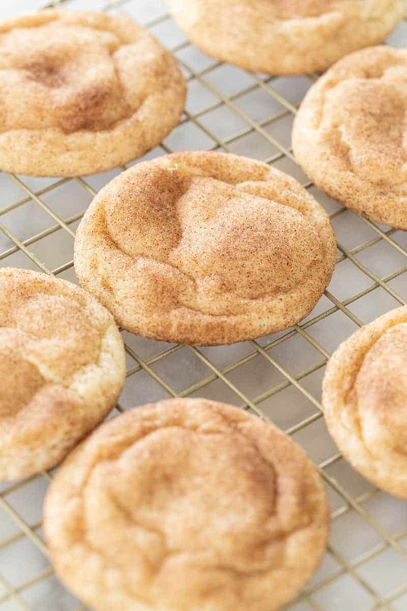 Chewy snickerdoodle recipe and cookies on a cookie rack.