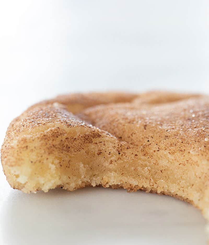 Chewy snickerdoodle cookie with a bite taken out of it.