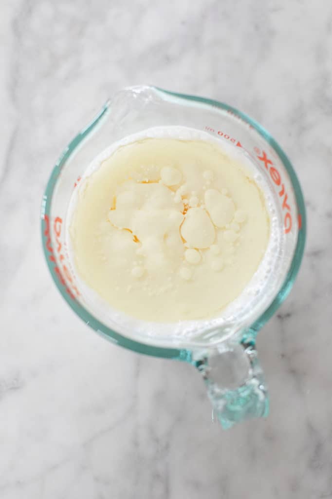Adding buttermilk and oil into a measuring cup to make homemade cupcakes. 