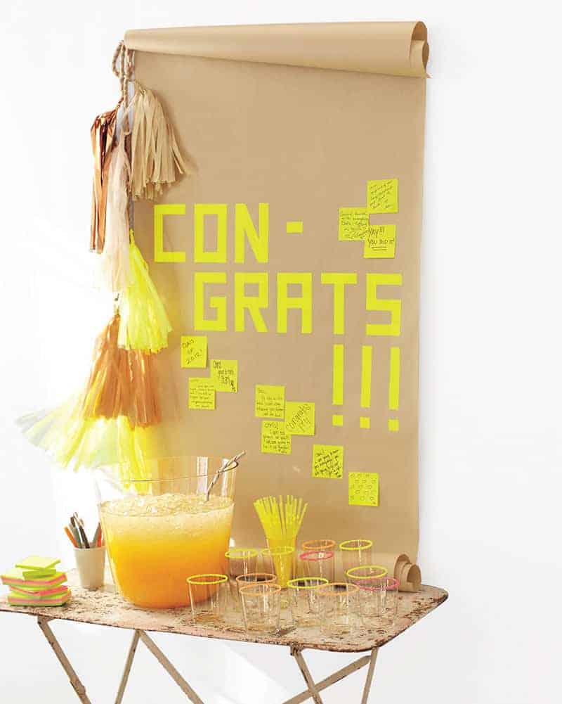 Graduation party with a brown paper sign an da punch bowl and neon details. - graduation cap