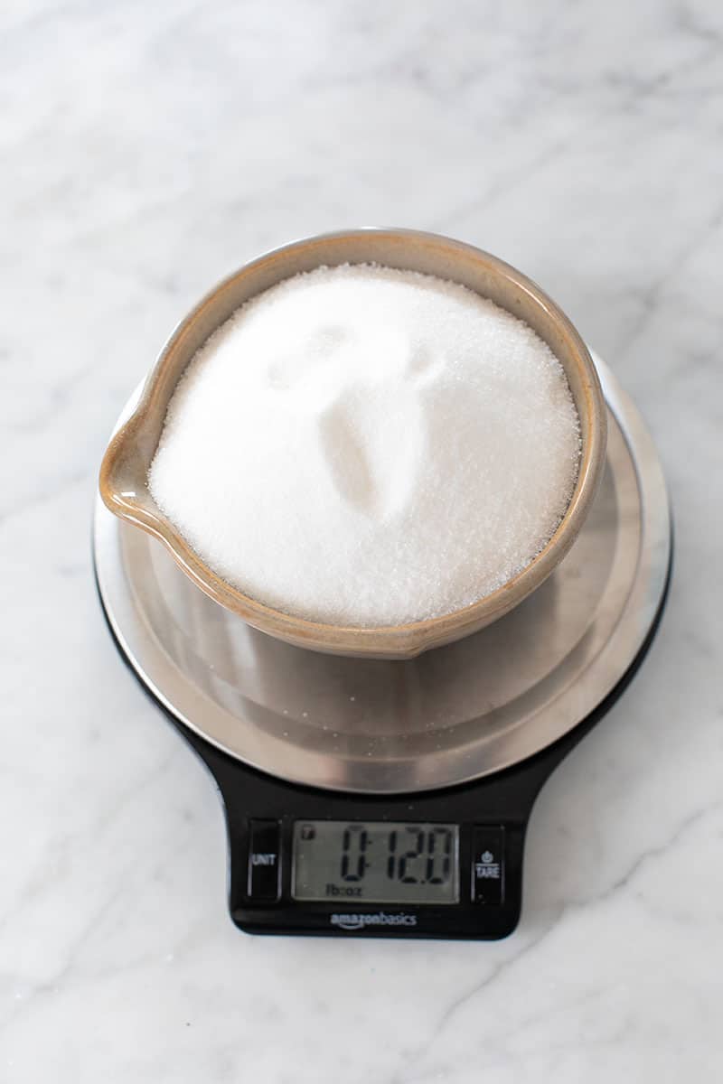 Cup of sugar on a kitchen scale. 